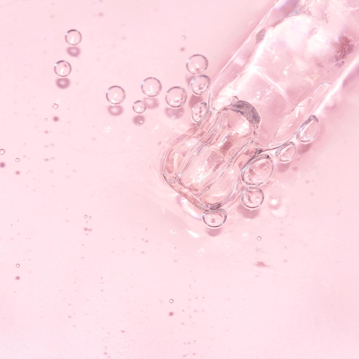 Detailaufnahme einer Pipette mit durchsichtiger, gelartiger Flüssigkeit auf altrosa Hintergrund. Es ist ein Sinnbild für den Inhaltsstoff Hyaluron.