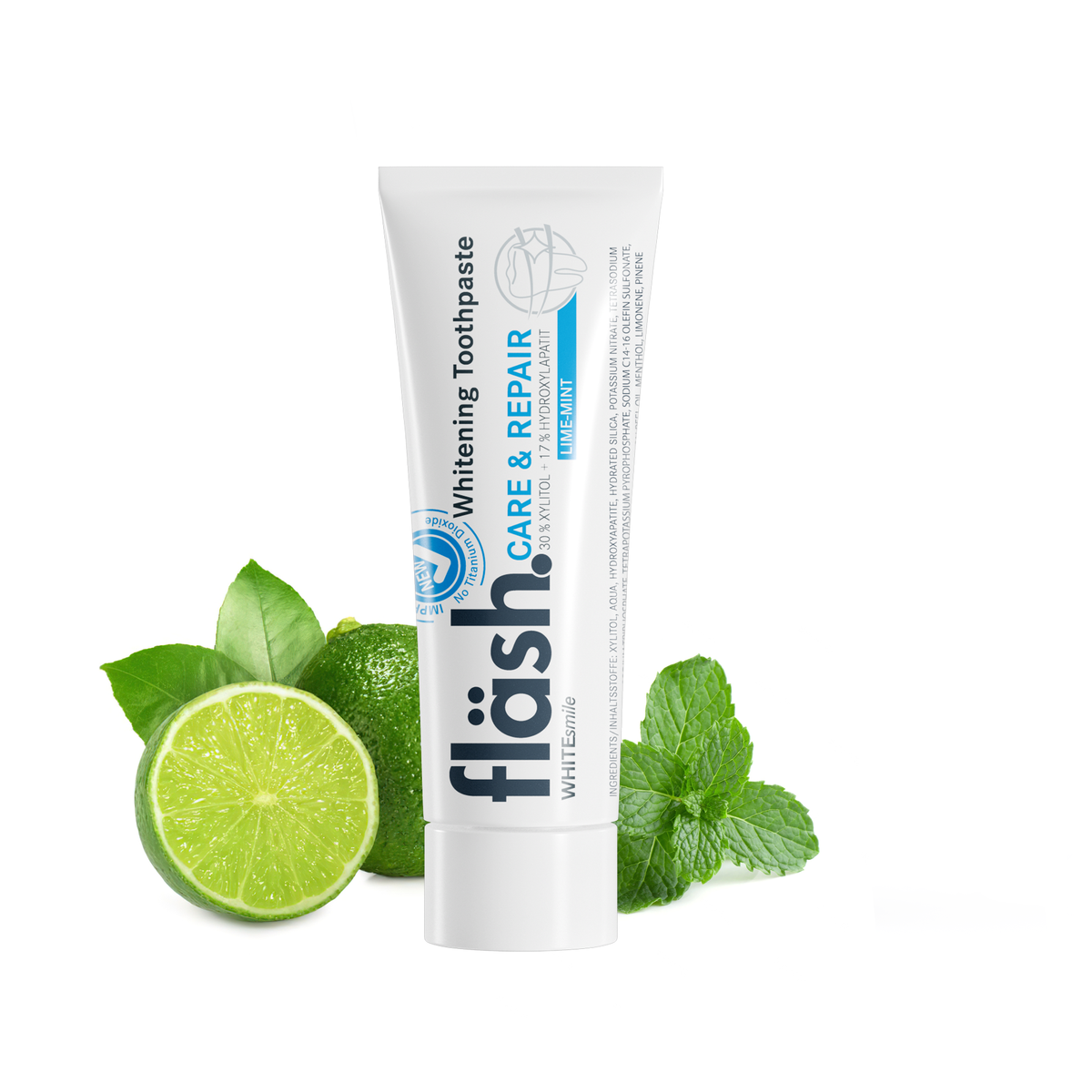 Eine Tube fläsh Zahnpasta Limette-Minze neben einer aufgeschnittenen Limette und Minzblättern.