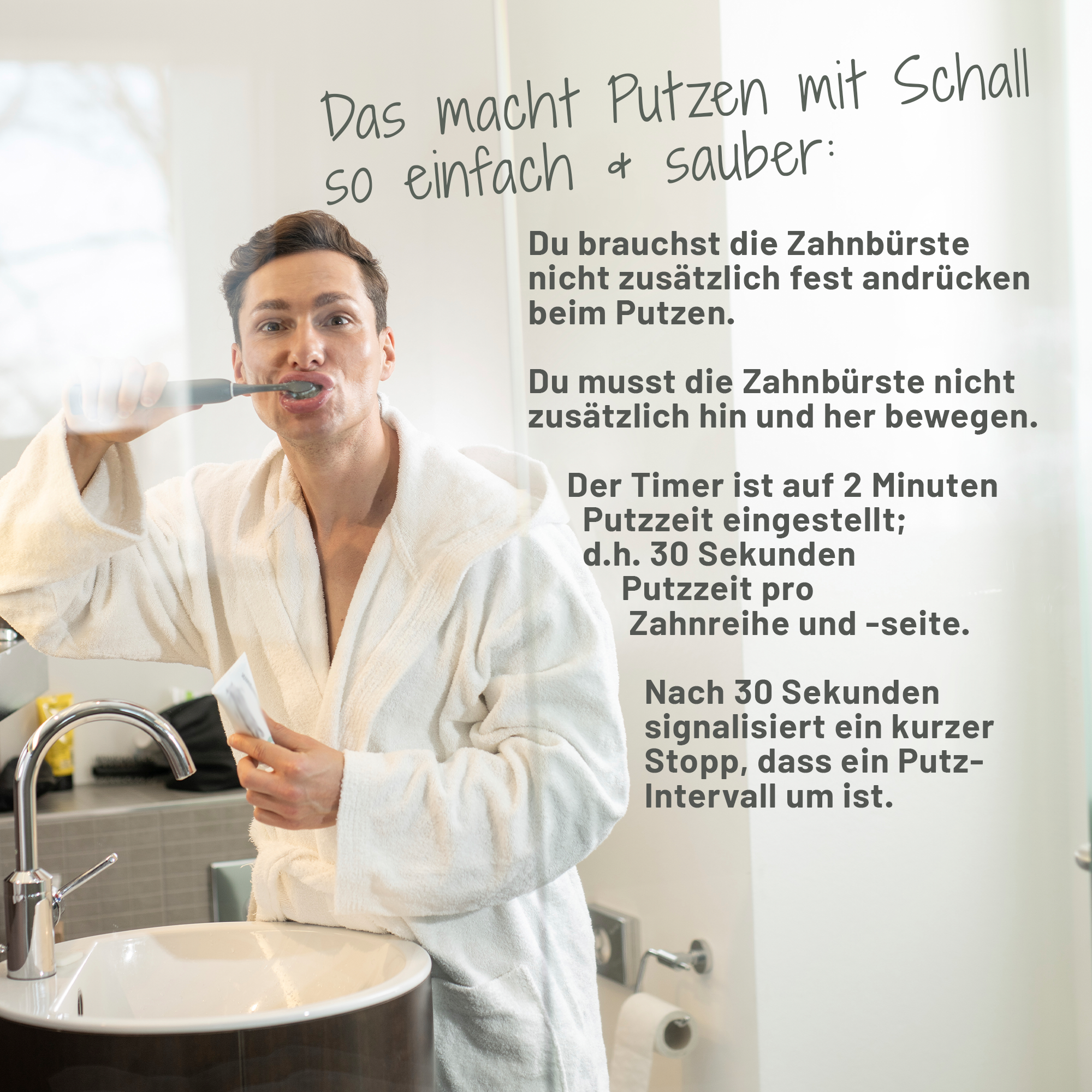 Ein junger, dunkelhaariger Mann in weißem Bademantel steht an einem Waschbecken im Badezimmer, schaut in die Kamera und putzt sich die Zähne mit der sträight Schallzahnbürste.