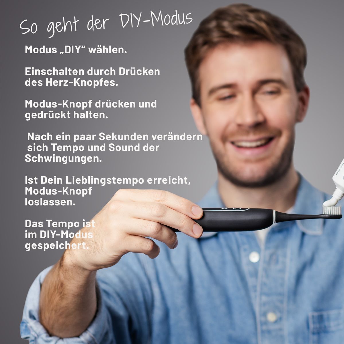 Ein junger Mann in legerem Jeanshemd gibt lächelnd etwas Zahnpasta auf die sträight Schallzahnbürste, die er in der rechten Hand hält.