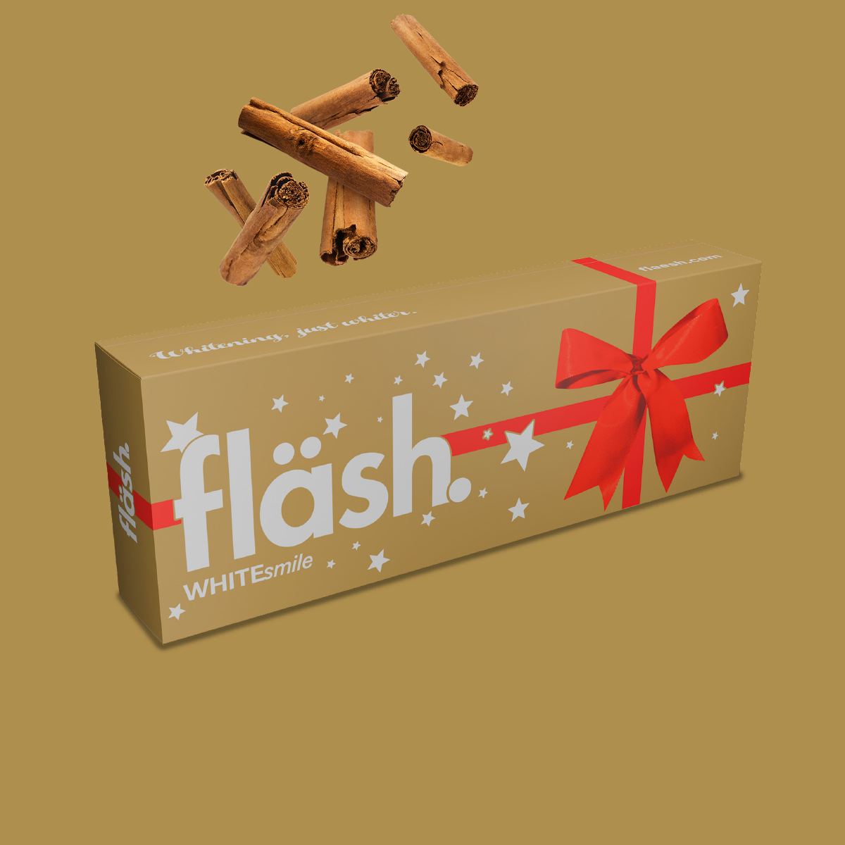 Auf goldenem Hintergrund liegt die ebenfalls goldene, mit roter Schleife versehene fläsh Weihnachts-Set, bestehend aus der fläsh xmas Zahnpasta mit Zimtgeschmack und passender Handzahnbürste.