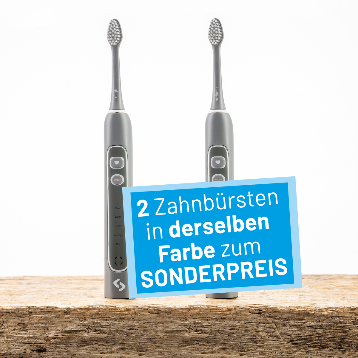 Zwei graue sträight Schallzahnbürsten stehen auf einer Holzplatte.